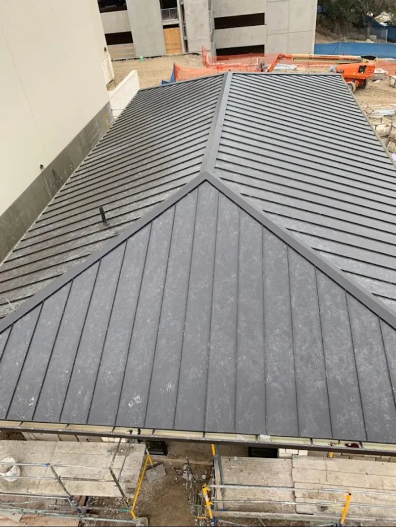 Commercial metal roof construction with crane equipment in Banning